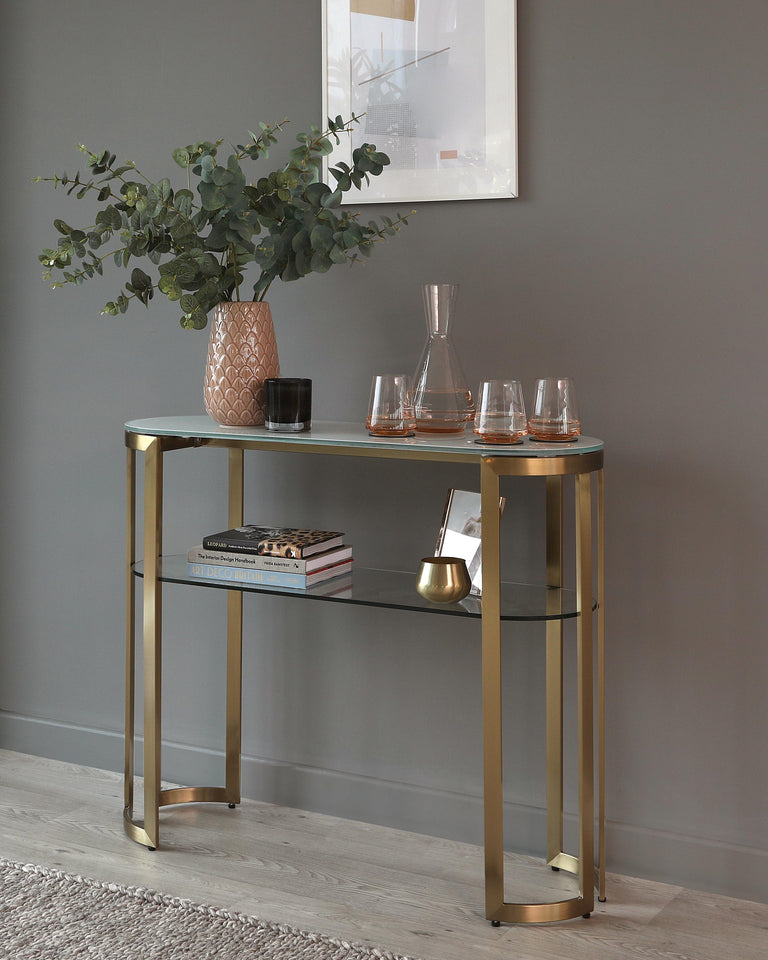 Elegant metal console table with a glass top and a lower glass shelf, finished in a brushed gold tone.