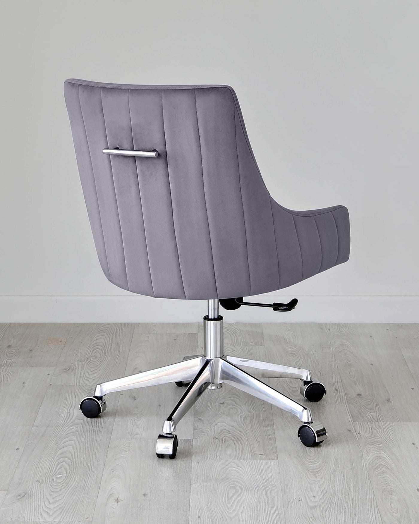 Modern grey office chair with horizontal channel tufting, a high back, sleek armrests, and a polished chrome base with five casters.