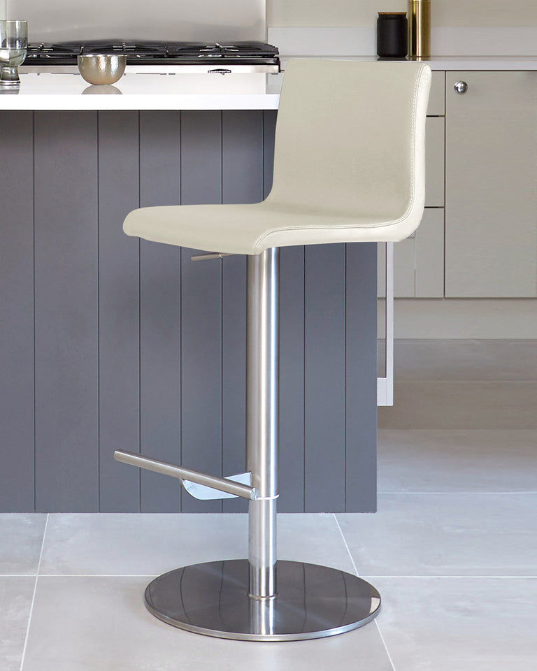 Modern adjustable-height bar stool with a curved backrest and padded seat in a light beige faux leather upholstery, featuring a sleek chrome pedestal base with a built-in footrest and a circular foundation.