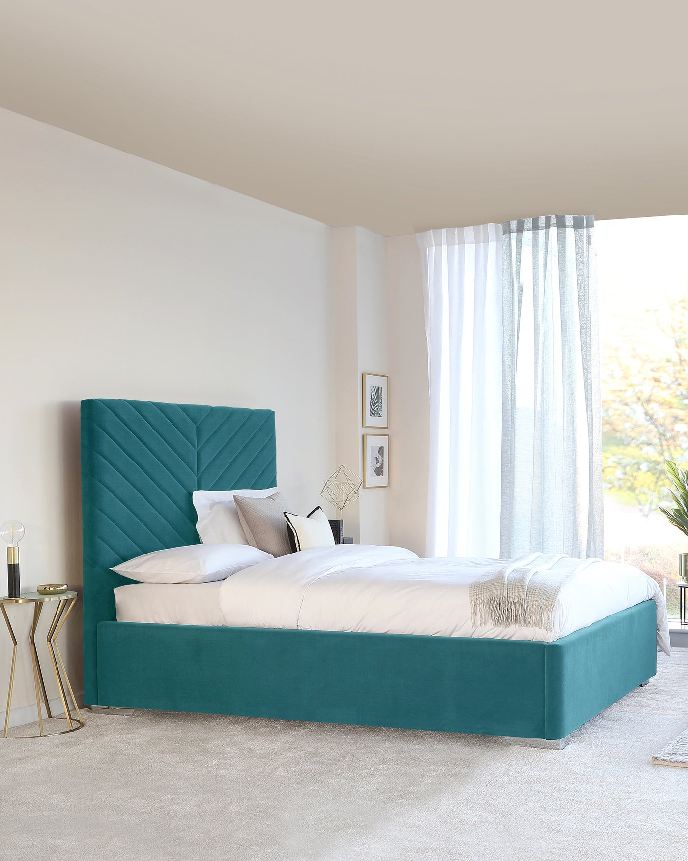 Elegant teal upholstered bed with a tall, tufted headboard, paired with a brass and glass circular side table.