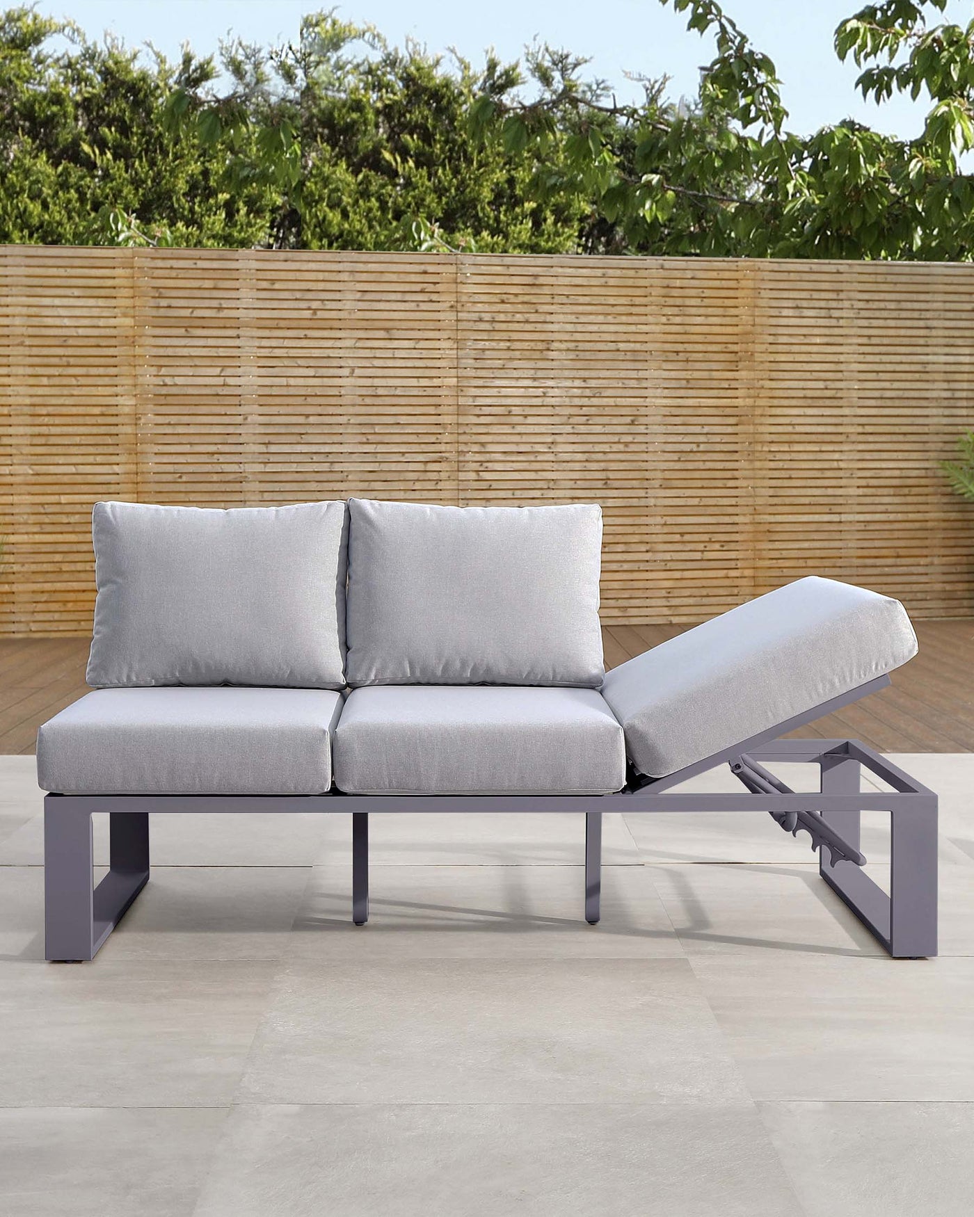 Contemporary outdoor sectional with a chaise lounge, featuring a sturdy grey aluminium frame with clean lines and grey cushions for a sleek and modern look.