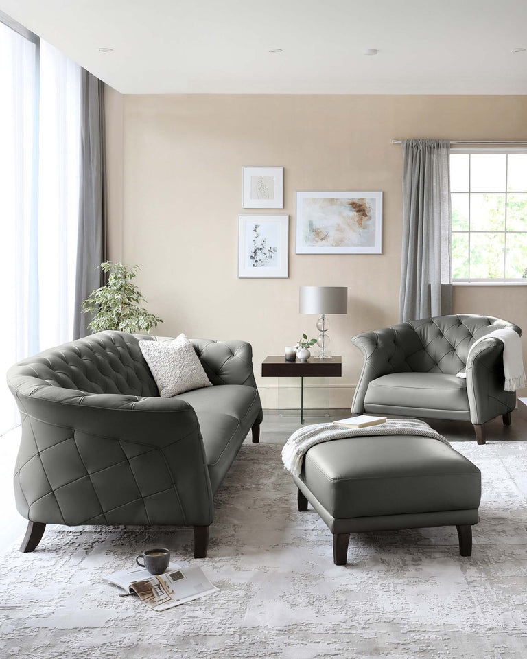 Elegant living room set featuring a tufted charcoal-grey sofa with a matching armchair and a square ottoman. Each piece includes dark wooden legs and diamond-patterned stitching that imparts a luxurious, sophisticated look. A white cushion accents the sofa, and a light grey throw blanket is draped over the ottoman.