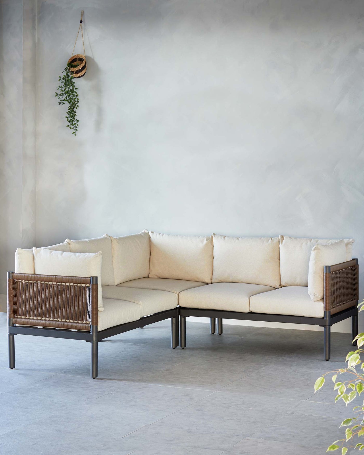 An L-shaped modular sofa with a minimalist design, featuring a sleek black metal frame and vertical wooden slats on the armrests. The sofa is upholstered with light beige cushions and accompanied by plush back pillows in a matching tone.