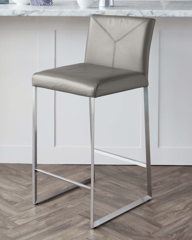 Modern grey faux leather bar stool with a high back and geometric stitch detailing, featuring a sleek, square-profiled stainless steel frame and footrest.