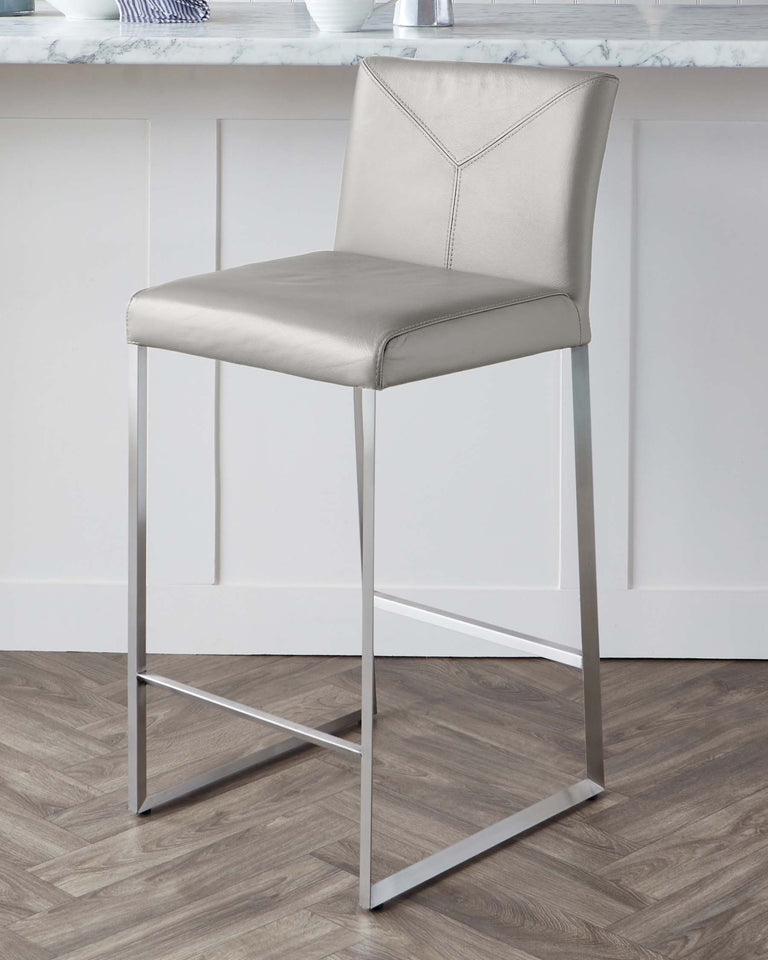 Modern bar stool with a sleek design, featuring a taupe leatherette seat and backrest with a decorative stitched detailing, supported by slender chrome-finished metal legs forming a square base for stability.