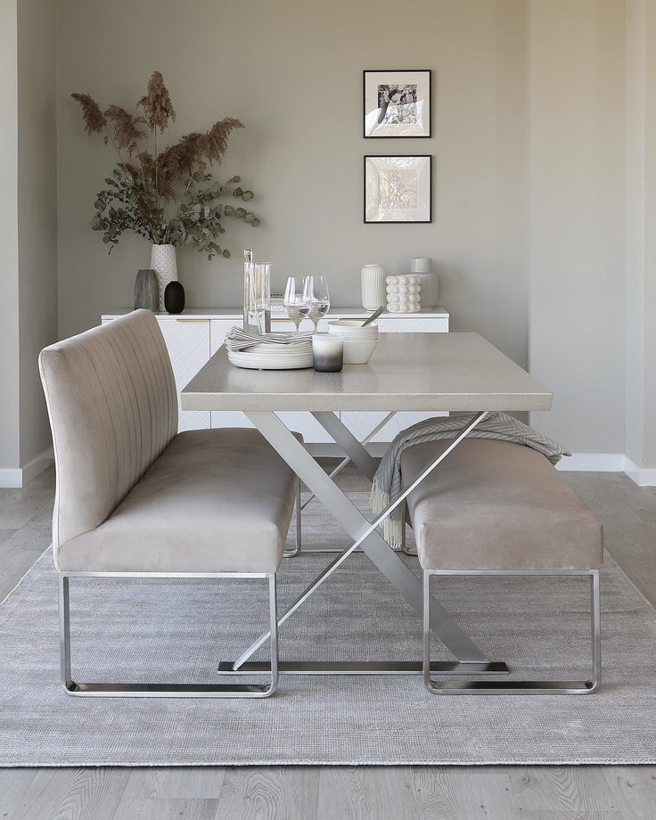 Dining set with a light grey table, bench and sofa on a grey rug, in front of a sideboard with art on the wall above.