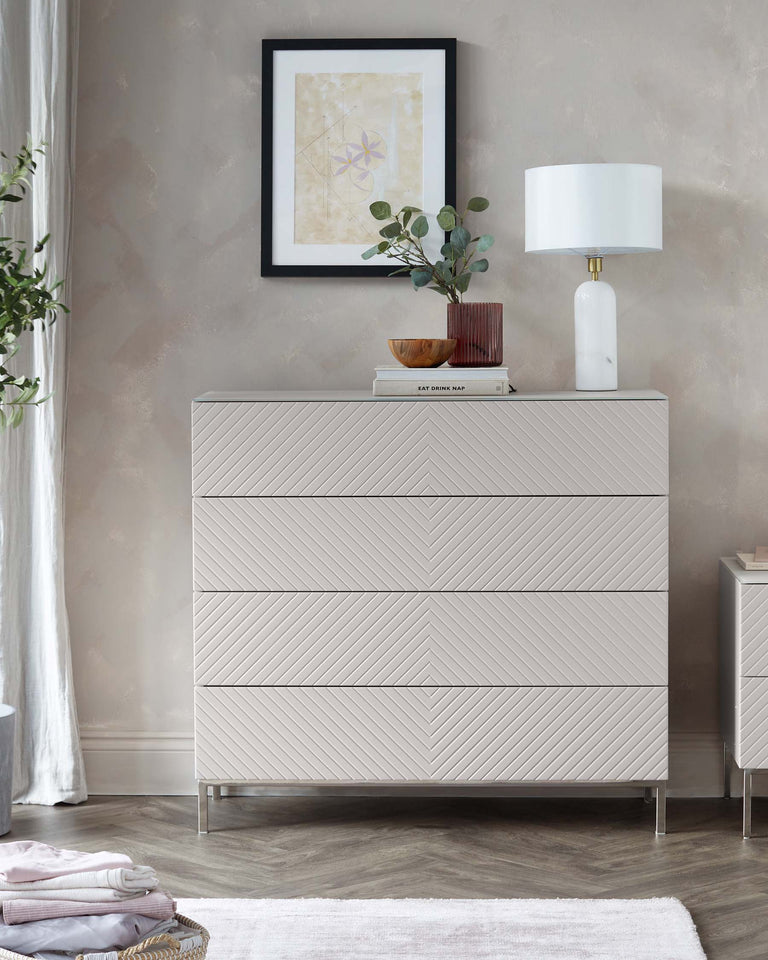 Modern light grey dresser with a textured chevron pattern across its drawers, sleek metallic handles, and thin, elegant metal legs.