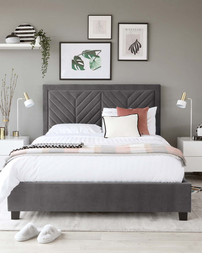 A modern, upholstered queen-size platform bed with a high headboard featuring elegant diagonal stitching. The bed is covered with a white comforter, accented by a patterned throw blanket and a selection of pillows in contrasting colours and patterns.