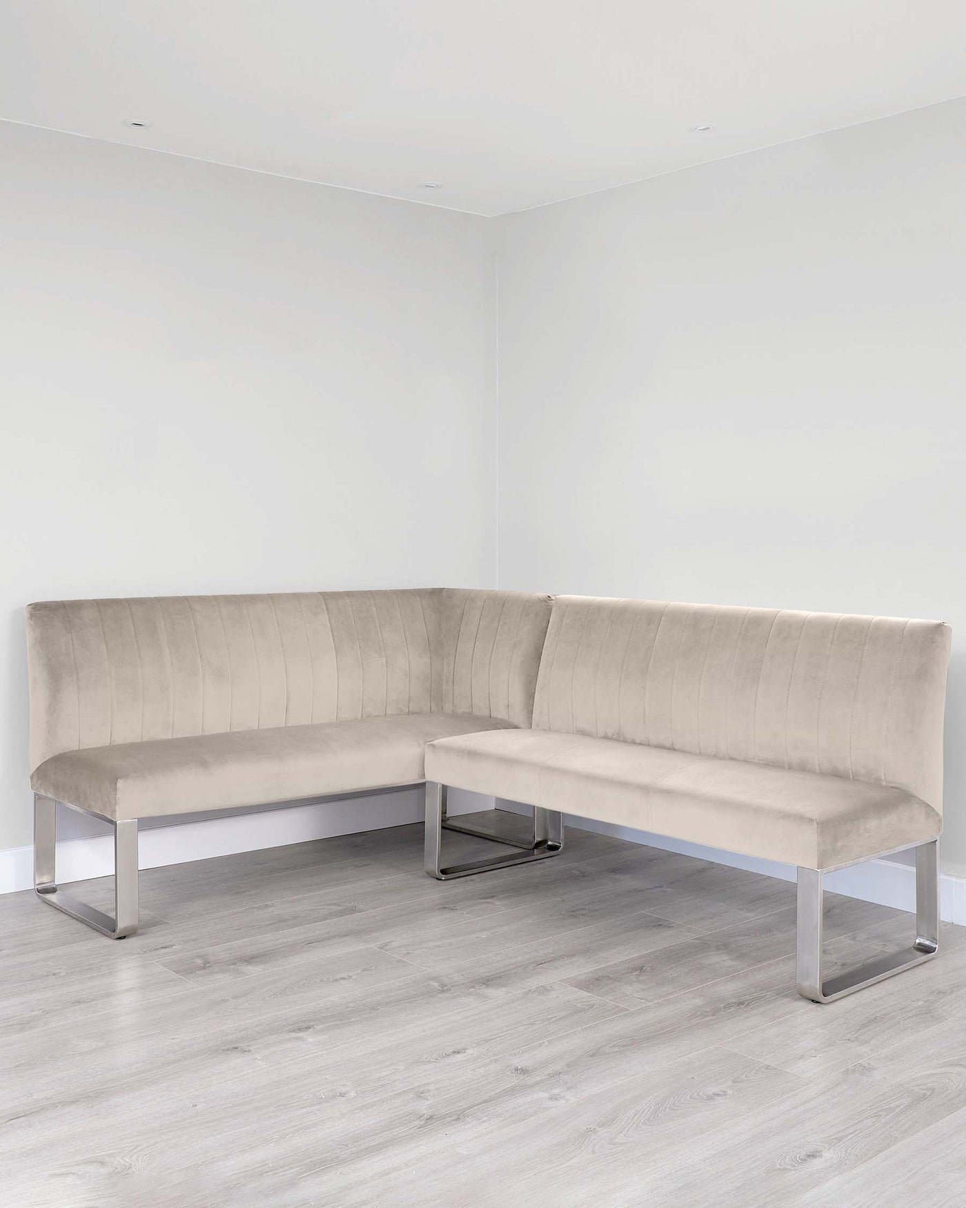 Modern L-shaped sectional bench with a plush, tufted velvet fabric in a neutral beige tone, featuring a clean-lined design supported by sleek, chrome-finished metal legs.