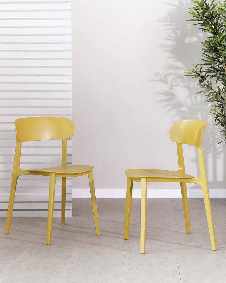 Two modern minimalist style yellow chairs with sleek lines and smooth surfaces, set against a neutral backdrop with a patterned white wall on the left and a potted plant to the right, creating a fresh and contemporary vibe for indoor settings.