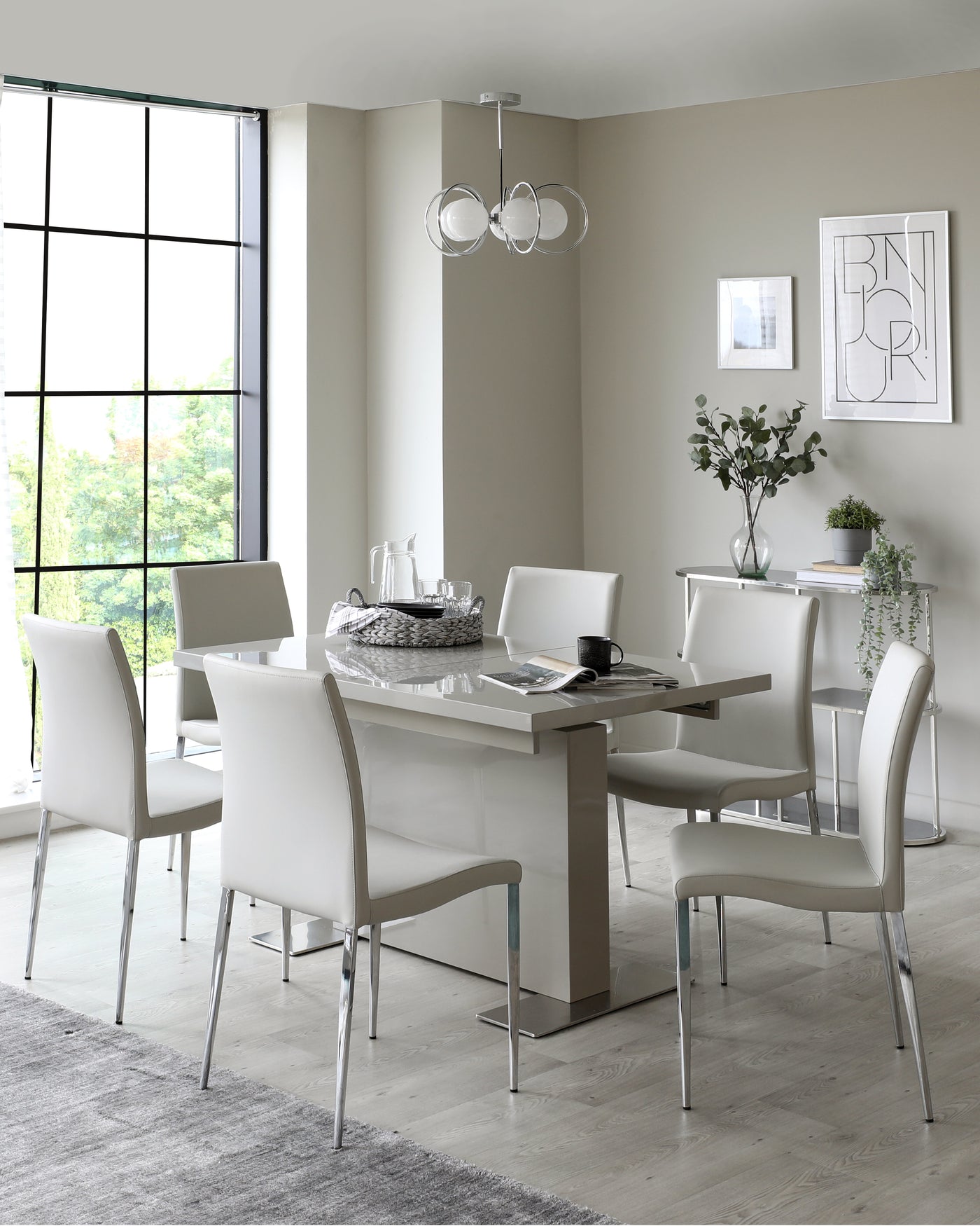 Modern dining room set featuring a sleek rectangular table with a reflective taupe base and a glass top, surrounded by six white upholstered chairs with chrome legs. A cosy yet sophisticated ensemble for contemporary interiors.