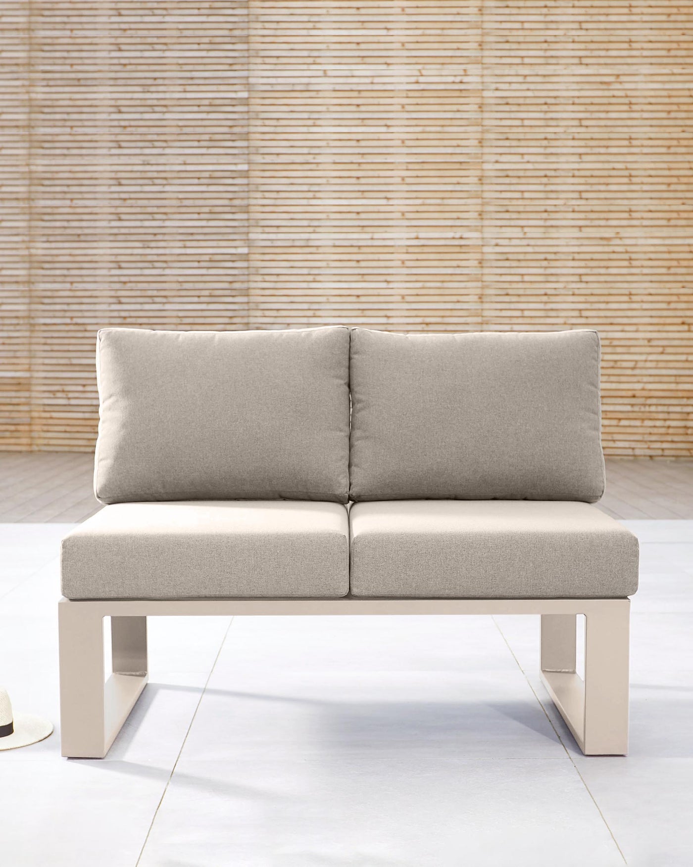 Modern two-seater sofa with light grey fabric upholstery and sleek rectangular metallic legs. The couch features a minimalist design with two plush back cushions and a continuous seat cushion, set against a warm, bamboo-textured wall, highlighting sharp lines and contemporary aesthetics.