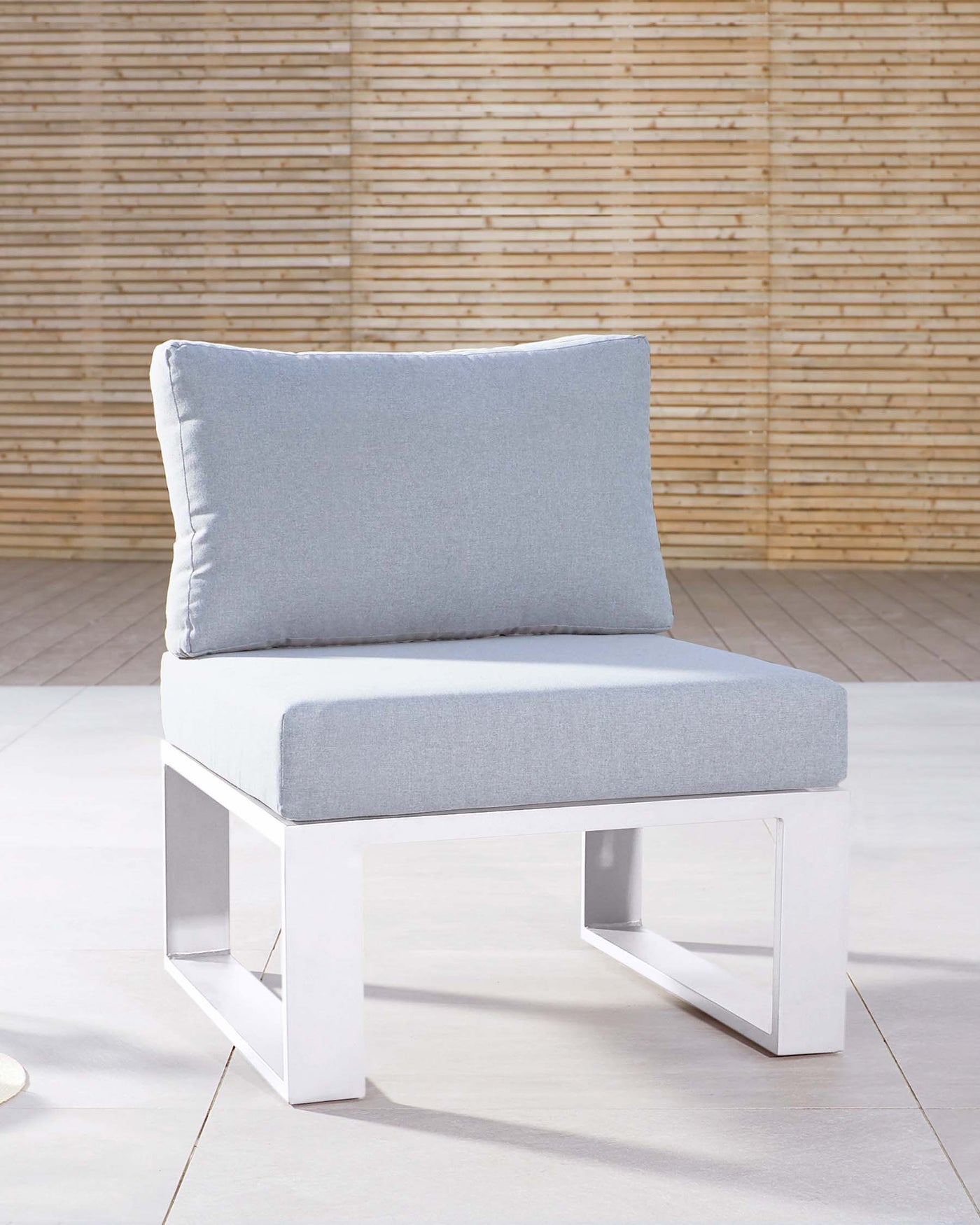 Modern minimalist single-seat modular sofa segment with light grey upholstery and a clean white metal base, positioned against a bamboo wall backdrop.
