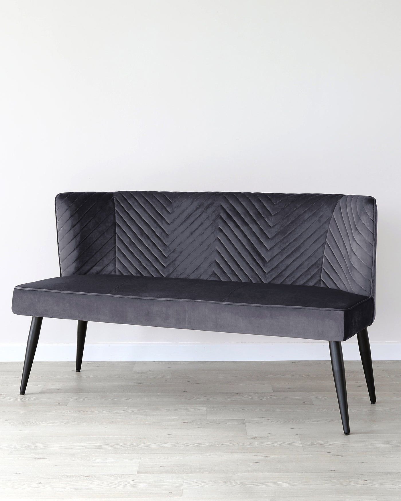Elegant contemporary sofa with a tufted chevron pattern on the backrest, upholstered in a dark grey fabric, and supported by four angled black legs.