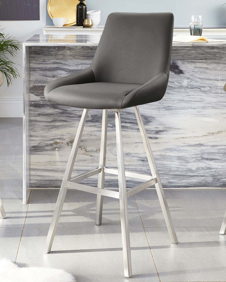 Modern grey upholstered bar stool with a curved backrest and sleek silver metal legs positioned in front of a marble-patterned credenza with decorative accents.