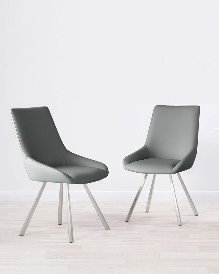 Two modern grey upholstered dining chairs with slender, angled metal legs situated on a light wood floor against a plain white background.