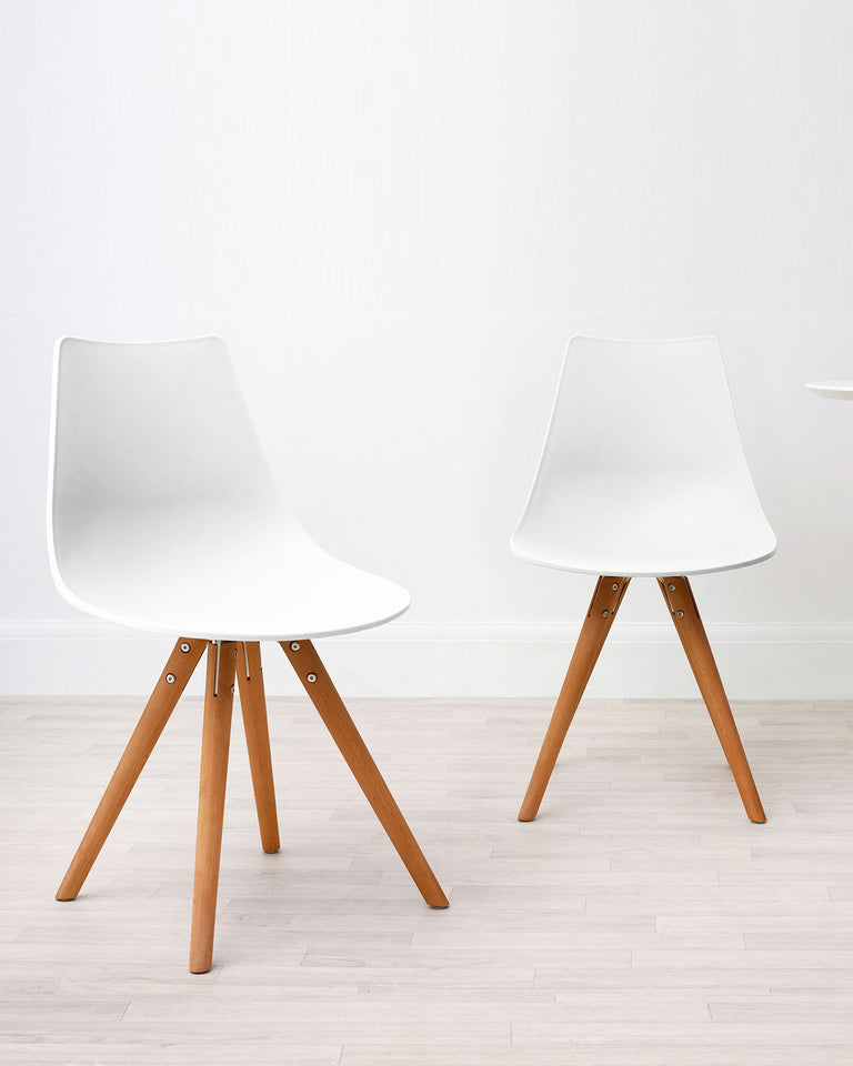 Two modern mid-century style chairs with white moulded seats and wooden tapered legs.