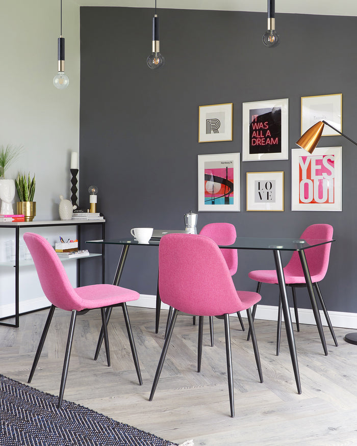 Modern dining area with a round glass-top table with black angled legs and four fuchsia upholstered chairs with slim, black metal legs. A sleek, black sideboard with decorative accents is also visible.